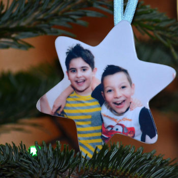 Stea personalizata cu poze plastifiate, prezentata in brad cu fotografia a doi copii