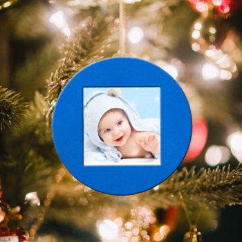 Glob albastru personalizat cu poza unui bebelus, agatat in brad
